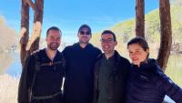 Four fellows pose for a photo outdoors while hiking